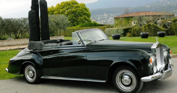 Кейдж има добре позната любов към английската култура и архитектура, като дори притежава имот в странния окръг Съмърсет поне от 2006 г. Освен това е голям фен на английските автомобили и е известно, че през гаража му са минали множество Rolls-Royce, включително някои невероятно редки. Това включва поне един кабриолет Rolls-Royce Silver Cloud III, въпреки че има доказателства зал два.

Първият е модел от 1964 г., само един от само 25-те произведени с ляв волан и с каросерия от HJ Mulliner. Той е боядисан в изключително необичаен нюанс на Velvet Green с черен капак. Първоначално е доставен в Германия преди да влезе в калифорнийската колекция на култовия актьор. Наскоро беше продаден от базирания в Обединеното кралство специализиран дилър Graeme Hunt за неразкрита сума.

Има обаче и друг кабриолет Silver Cloud III, за който се твърди, че е бил собственост на Кейдж, модел от 1963 г. Той изглежда е бил боядисан в бяло и след това в кафяво. Историята на тази конкретна кола е по-трудно проверима. Ако е наистина така, Кейдж я продава някъде преди 2008 г.